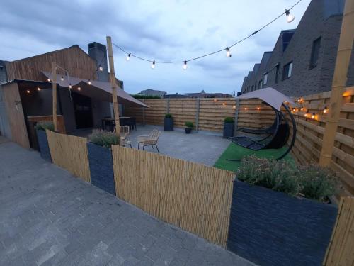 a backyard with a wooden fence and a patio at Guesthouse 66 in Lommel