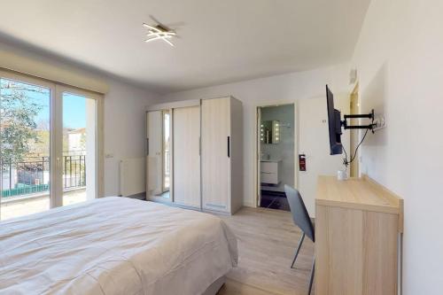 Schlafzimmer mit einem Bett, einem Schreibtisch und einem TV in der Unterkunft 10.Studio#Creteil#Loft#Cinéma in Créteil