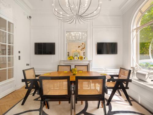 a dining room with a table and chairs and a chandelier at Solly H&ocirc;tel Paris in Paris