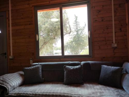 a couch sitting in a room with a window at Moskato Vilas in Himare