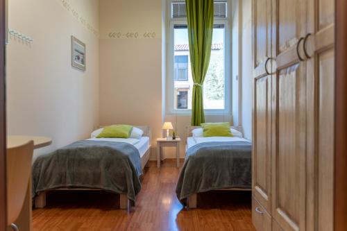 a room with two beds and a window at Hotel Stara šola - Oleander Resort in Izola