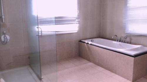 a bathroom with a tub and a shower and a sink at Sealinks city - Tvila in Phan Thiet