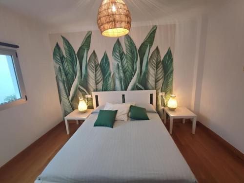 ein Schlafzimmer mit einem großen Bett mit grünen Kissen in der Unterkunft Luxury apartment Las Canteras in Las Palmas de Gran Canaria