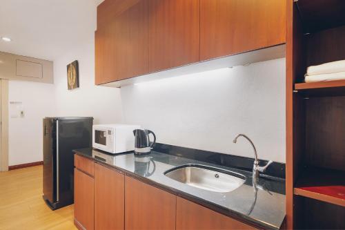 a kitchen with a sink and a microwave at Chateau Dale Boutique Resort Spa Villas in Pattaya South