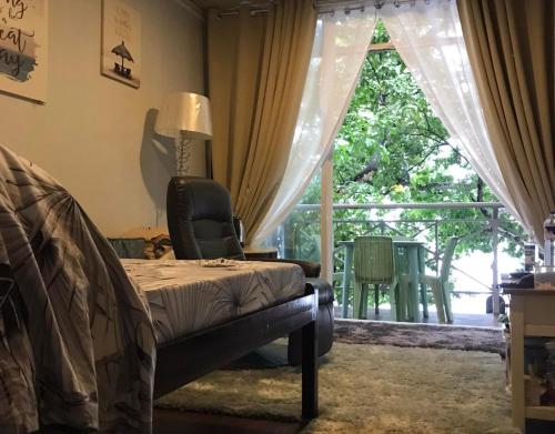1 dormitorio con cama y ventana grande en Happy Daze Resort Hotel, 