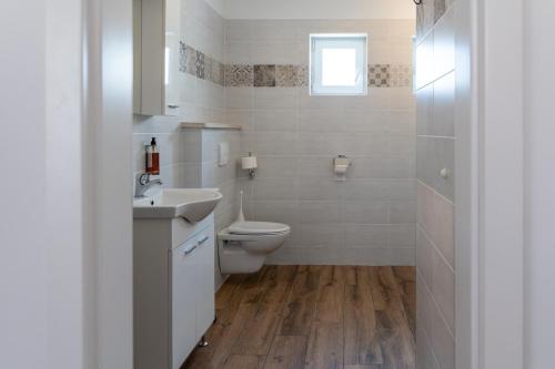 uma casa de banho branca com um WC e um lavatório em Hotel Stara šola - Oleander Resort em Izola