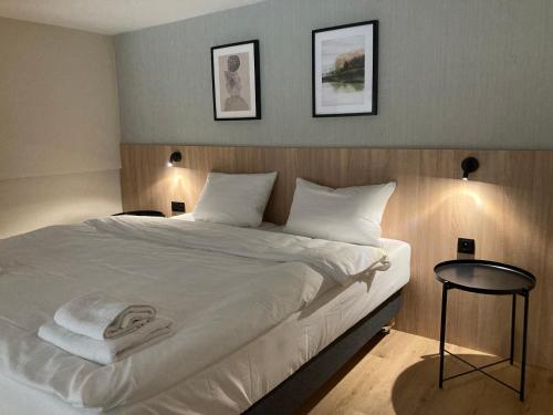 a bedroom with a large white bed with two pictures on the wall at Apartament Laguna Beskidów 76 przy Jeziorze Żywieckim - Dream Apart in Zarzecze