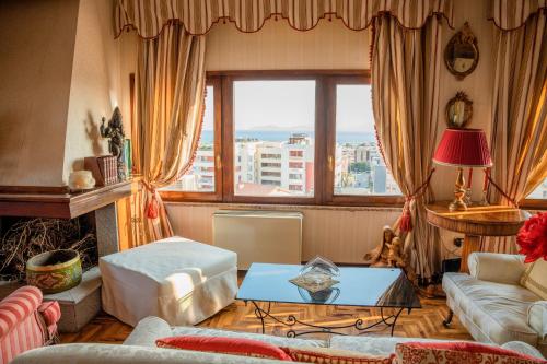 un soggiorno con divano e tavolo di Prestigioso Attico Panoramico Cagliari a Cagliari