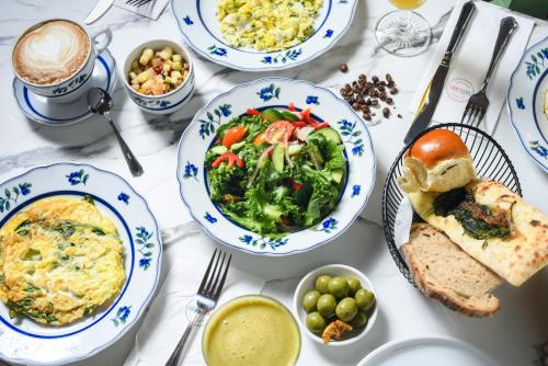 a white table with plates of food on it at Carmella Boutique Hotel in Haifa
