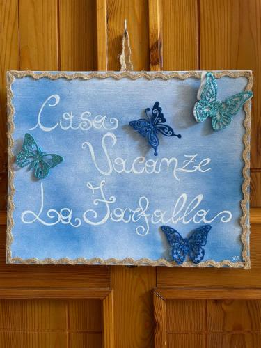 a sign with butterflies on top of a wall at Casa vacanze La Farfalla in San Vito Chietino