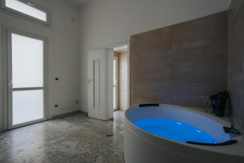 B&B Nuovo Reale - CENTRO STORICO في ليتشي: حمام كبير مع حوض كبير في الغرفة