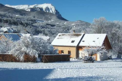 CrotsにあるVue sur embrun lac de serre-ponçonの山を背景に雪に覆われた家