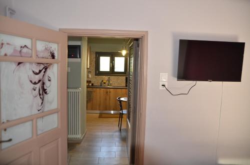 a hallway with a door with a television on a wall at Persefoni's Home in Ioannina