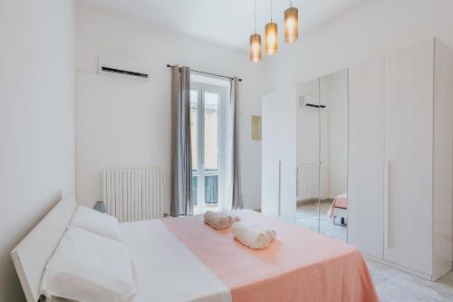 una camera bianca con un letto con due cuscini sopra di B&B Nuovo Reale - CENTRO STORICO a Lecce