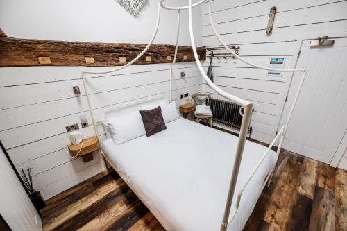 Bett in einem Zimmer mit weißen Wänden in der Unterkunft Bashall Barn in Clitheroe