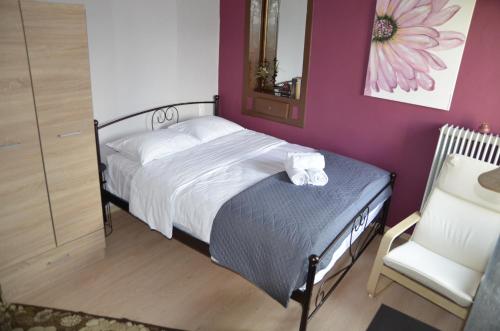 ein kleines Schlafzimmer mit einem Bett und einem Stuhl in der Unterkunft Persefoni's Home in Ioannina