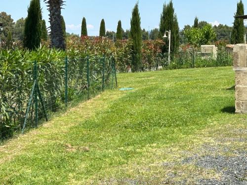a garden with a fence and a field of grass at Fattoria Palazzeta - Pet & Family Friendly in Cecina