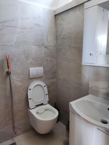 a bathroom with a white toilet and a sink at Moskato Vilas in Himare