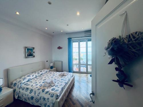 ein Schlafzimmer mit einem Bett und einem großen Fenster in der Unterkunft La casa delle favole in Civitavecchia