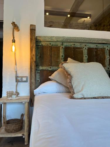 a bedroom with a bed with a wooden headboard and a table at La Lolita ( Adults Only ) in Sant Martí Vell