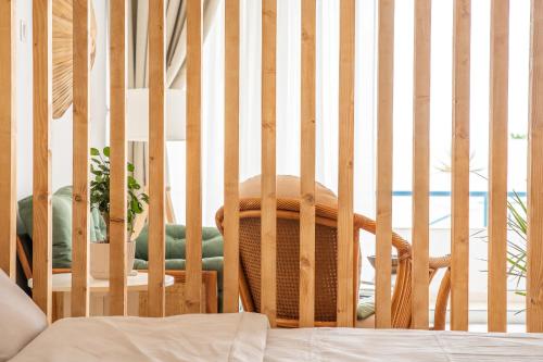 a wooden crib with a chair in a room at Pissouri bay studio in Pissouri