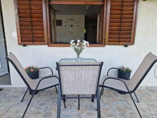 a table with two chairs and a clock on a wall at Apartment MMP in Kotor