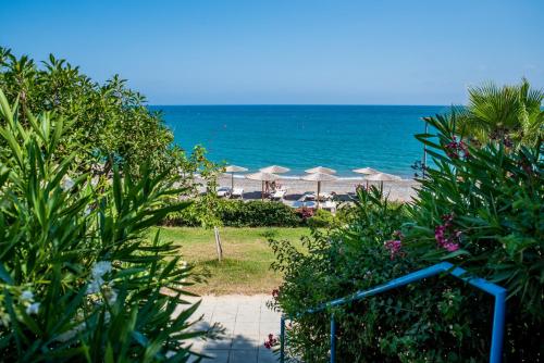 a beach with umbrellas and the ocean in the background at Pissouri bay studio in Pissouri