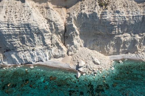 an aerial view of a rocky shore with a body of water at Pissouri bay studio in Pissouri