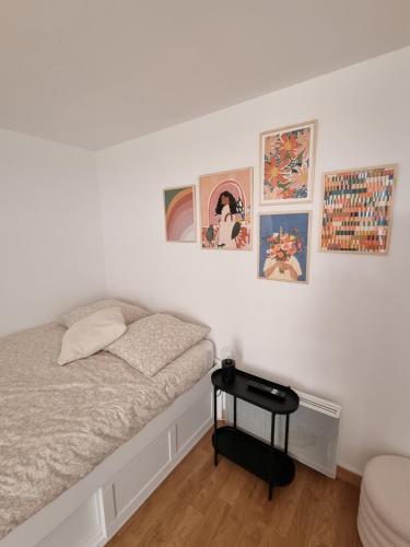 une chambre avec un lit et des tableaux au mur dans l'établissement Joli studio hyper-centre, à Nantes