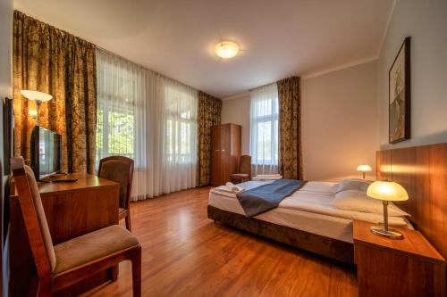 a bedroom with a bed and a desk and a chair at Apartament w willi Rybitwa in Międzyzdroje