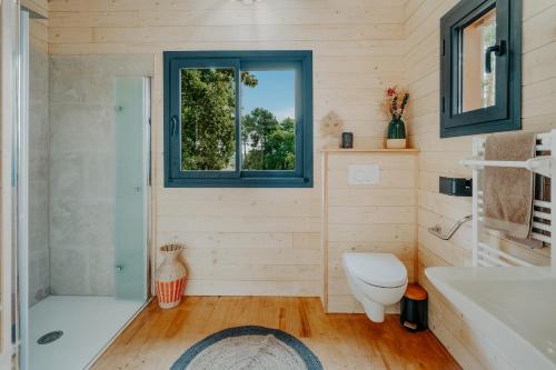 a bathroom with a tub and a toilet and a sink at Les Cabanes Girondines-Lodges & Spa in Martillac