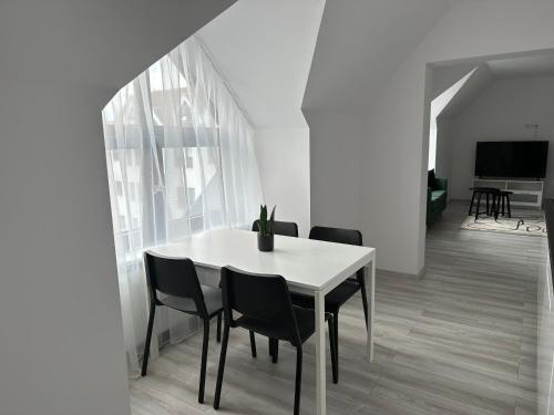 a dining room with a white table and chairs at Apartamenty Przy Deptaku in Świnoujście