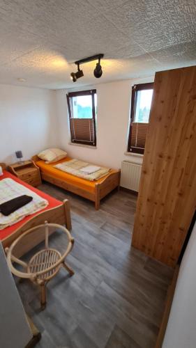 Habitación con 2 camas y una silla. en Ferienwohnung Anders en Kodersdorf