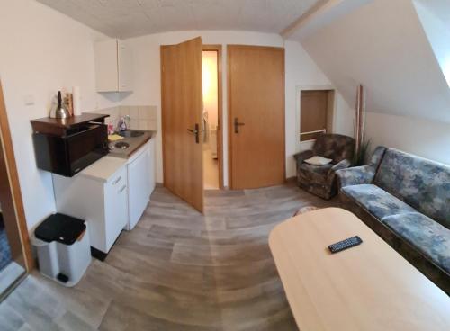 pequeña sala de estar con sofá y cocina en Ferienwohnung Anders en Kodersdorf