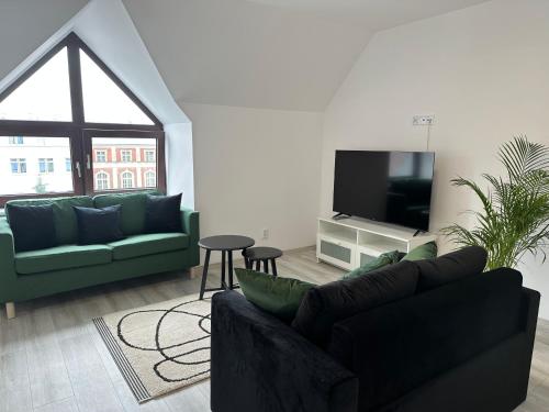 a living room with two couches and a flat screen tv at Apartamenty Przy Deptaku in Świnoujście