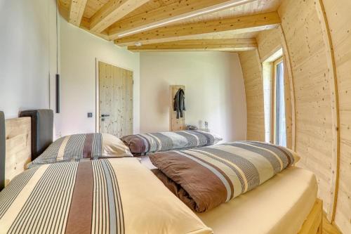 two beds in a room with wooden ceilings at Chalet Panorama-Skydome in Neukirchen vorm Wald