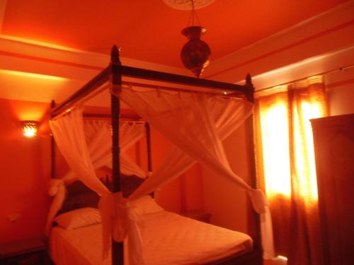 a bedroom with a canopy bed and a window at Cleopatra Hotel Luxor in Luxor