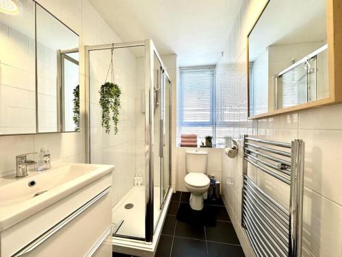 La salle de bains blanche est pourvue d'un lavabo et de toilettes. dans l'établissement City Centre Hidden Hideout for 2, à Édimbourg