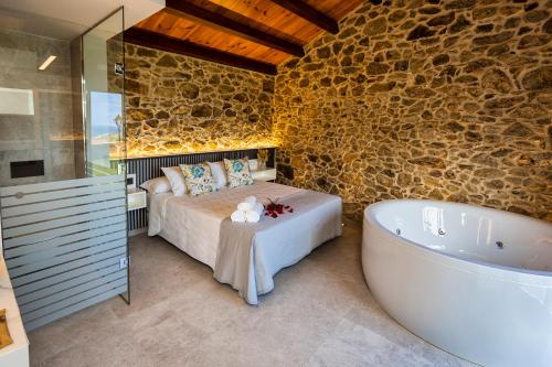 a bedroom with a bed and a bath tub in a room at Sal de Mar Apartamentos in Muxia