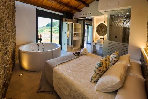 a bedroom with a large bed and a bath tub at Sal de Mar Apartamentos in Muxia