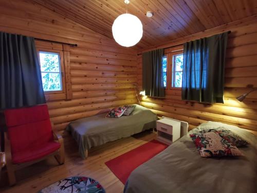 a room with two beds in a log cabin at Uuvana in Syöte
