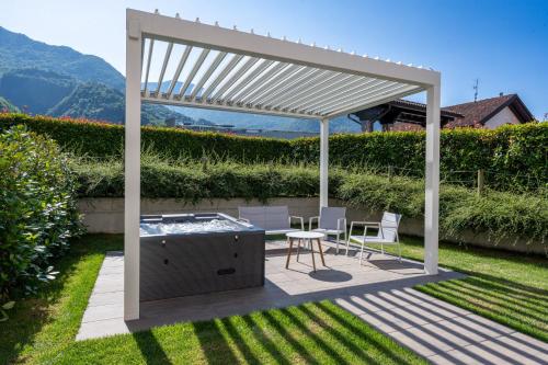 a pergola over a patio with a table and chairs at Bianco Hotel in Primaluna