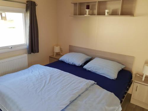1 dormitorio con 1 cama con 2 almohadas en Chalet Silbermöwe am Kransburger See 548, en Kransburg