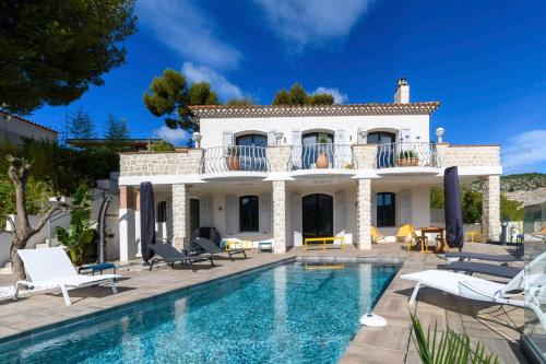 a villa with a swimming pool in front of a house at Villa Talabar in Cassis
