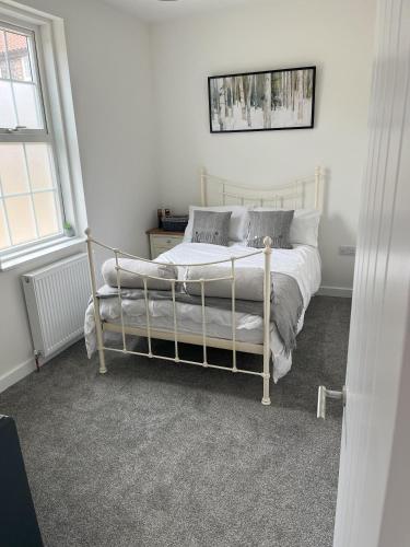 sypialnia z łóżkiem w białym pokoju w obiekcie 2BR Bungalow, Garden, Near Races w mieście Newmarket