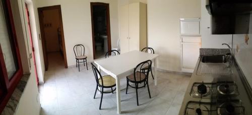 a white table and chairs in a kitchen at Villaggio Magna Grecia in Lazzaro