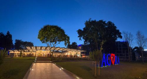 un gran edificio de noche con luces encendidas en Hotel Agora, en Neptun