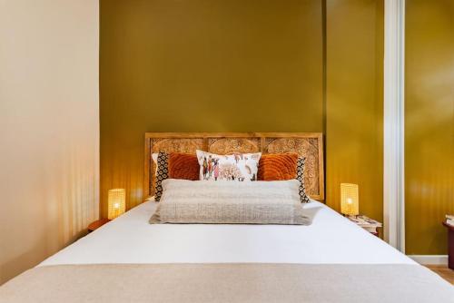 um quarto com uma cama grande com lençóis brancos e paredes cor-de-laranja em Cascais Modern & Quiet Retreat em Cascais