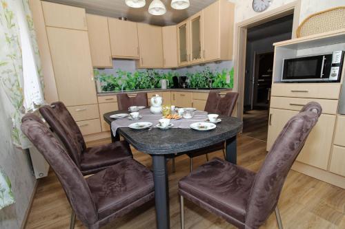 a dining room with a table and chairs in a kitchen at Ferienhaus am Ostfrieslandwanderweg, 15177 in Leer