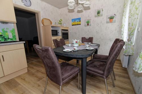 a kitchen and dining room with a table and chairs at Ferienhaus am Ostfrieslandwanderweg, 15177 in Leer